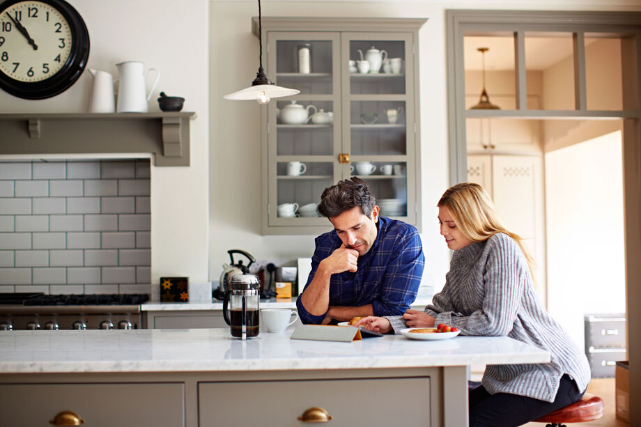 A couple sat in the kitchen looking at paperwork