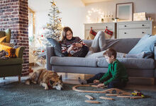 Family sat in the living room with surrounding Christmas decorations and toys