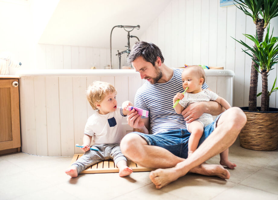 Father in the bathroom with his children brushing their teeth