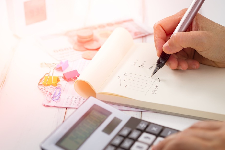 Person using a calculator and notepad