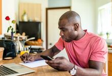 Person with calculator and laptop at table