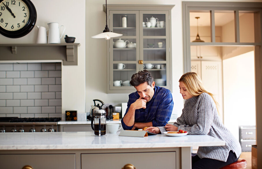 Couple looking at a laptop in the kitchen