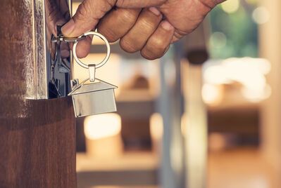 Person opening door with a key