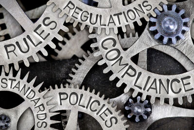 Cogs with the words compliance, regulation, policies on them