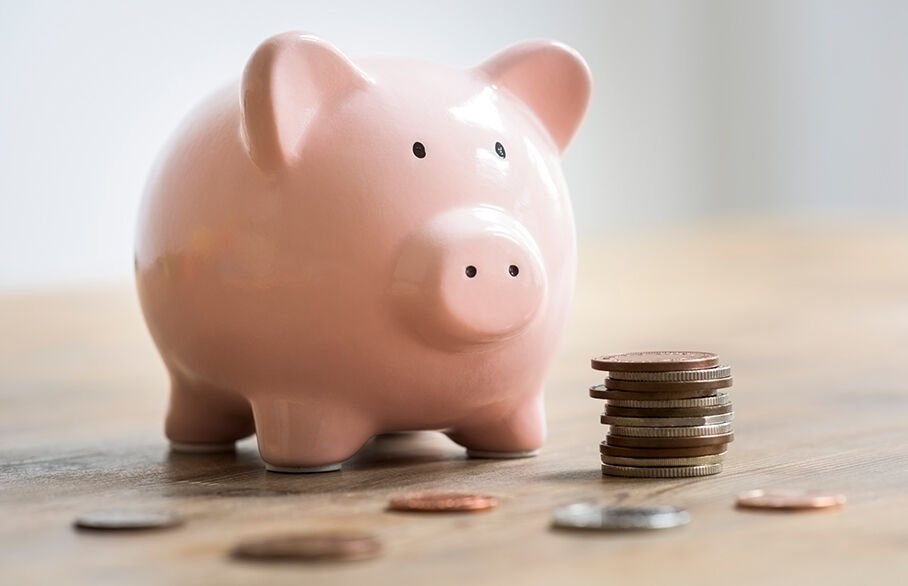 A piggy bank beside a stack of coins