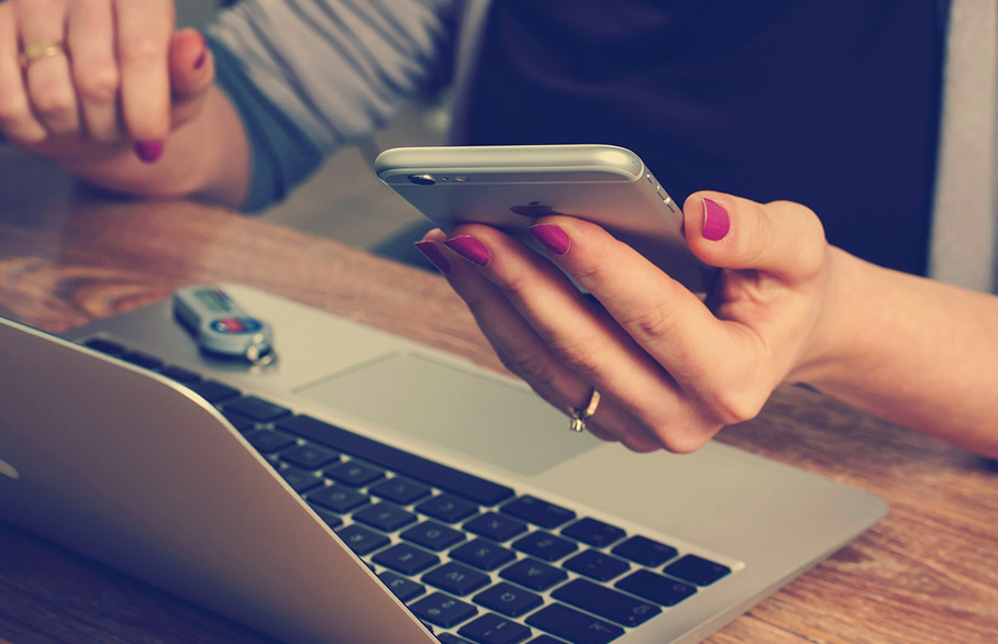 Woman with laptop checking phone