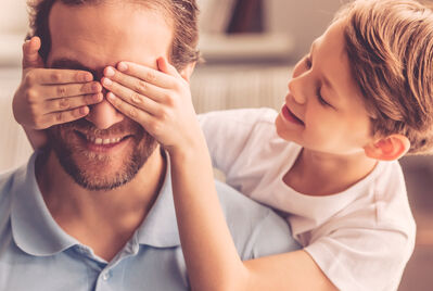 Child placing their hands over adults face