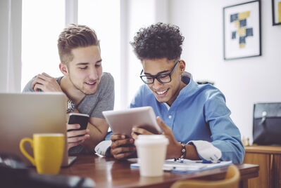 Two people looking at a laptop in the home