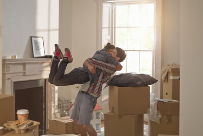 Couple embracing a cuddle surrounded by moving boxes