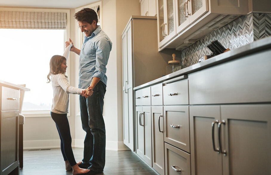 Dad dancing with daughter in the kitchen