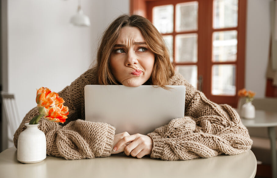 Person sat at a table with chin resting on tablet looking confused