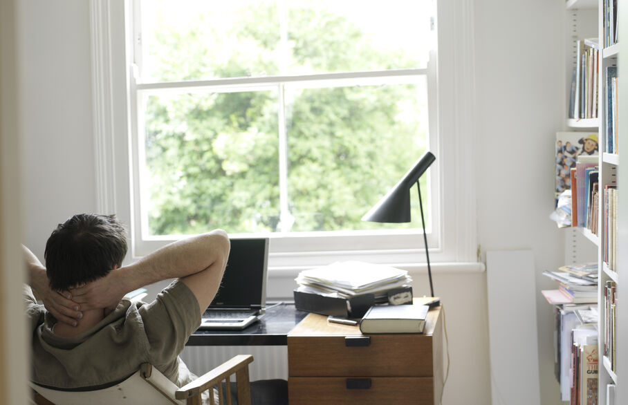 man at desk with hands up