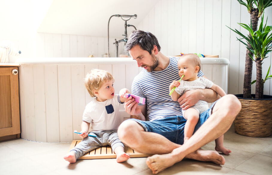 Family of three sat on the floor in the bathroom