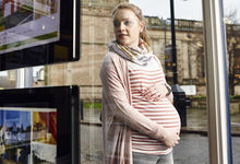 Pregnant woman looking at property advertisements
