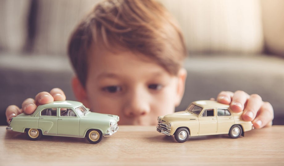 Boy playing with two cars