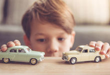 Boy playing with two cars