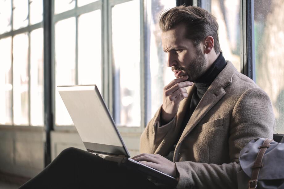 Confused man looking at laptop