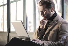 Confused man looking at laptop