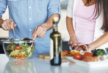 Couple in the kitchen making salad