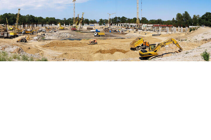 Large construction site with cranes, excavators and earth-moving vehicles