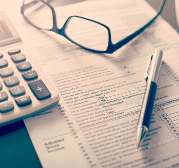 A miniature house laid on top of money